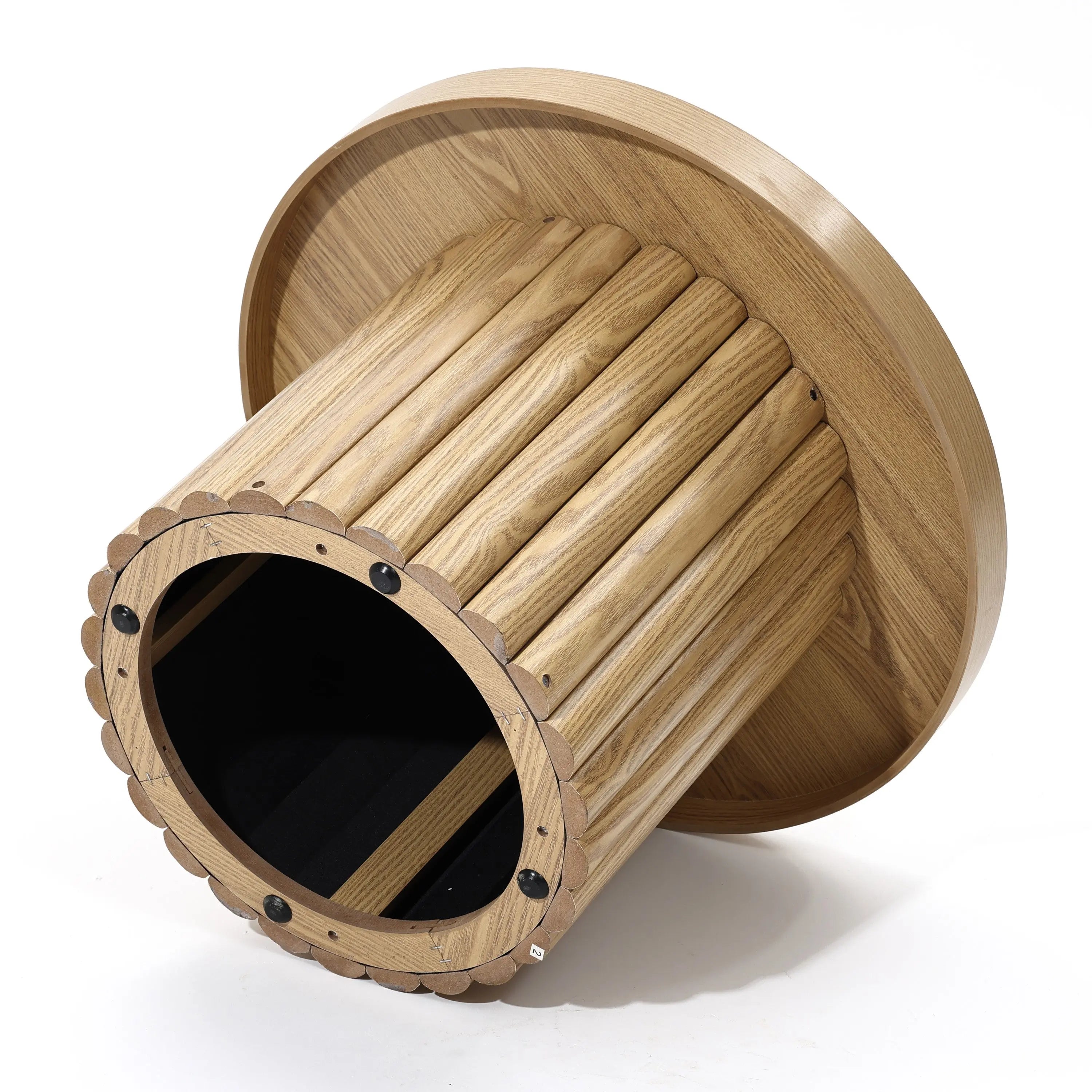 A wooden cylindrical cat tunnel with a scalloped edge, lying on its side, seamlessly blends into your living space with its modern design and oak finish, almost resembling a unique coffee table.