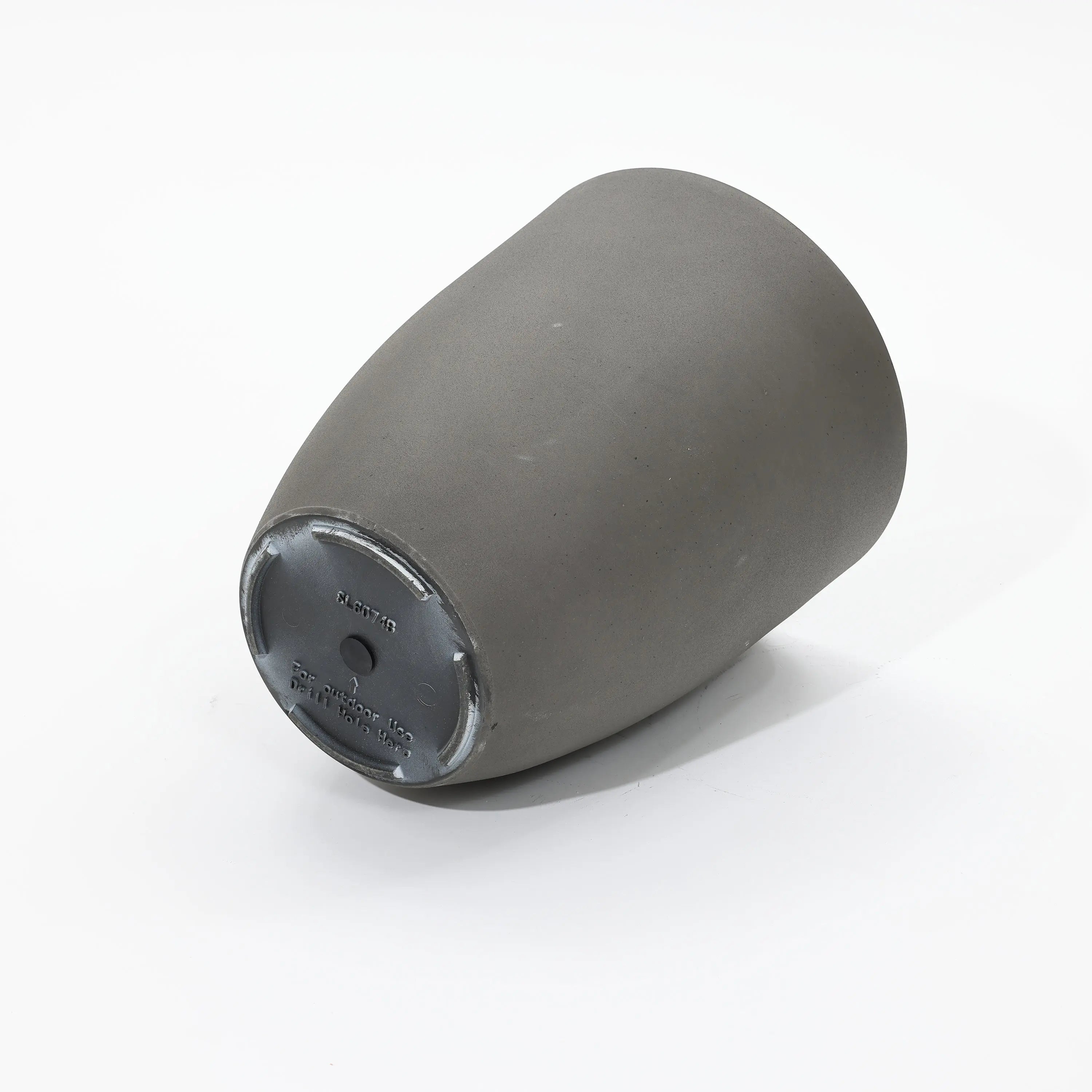 A gray, cylindrical ceramic mug lies on its side, revealing the base and inner rim, suggesting a potential transformation into a modern planter set.