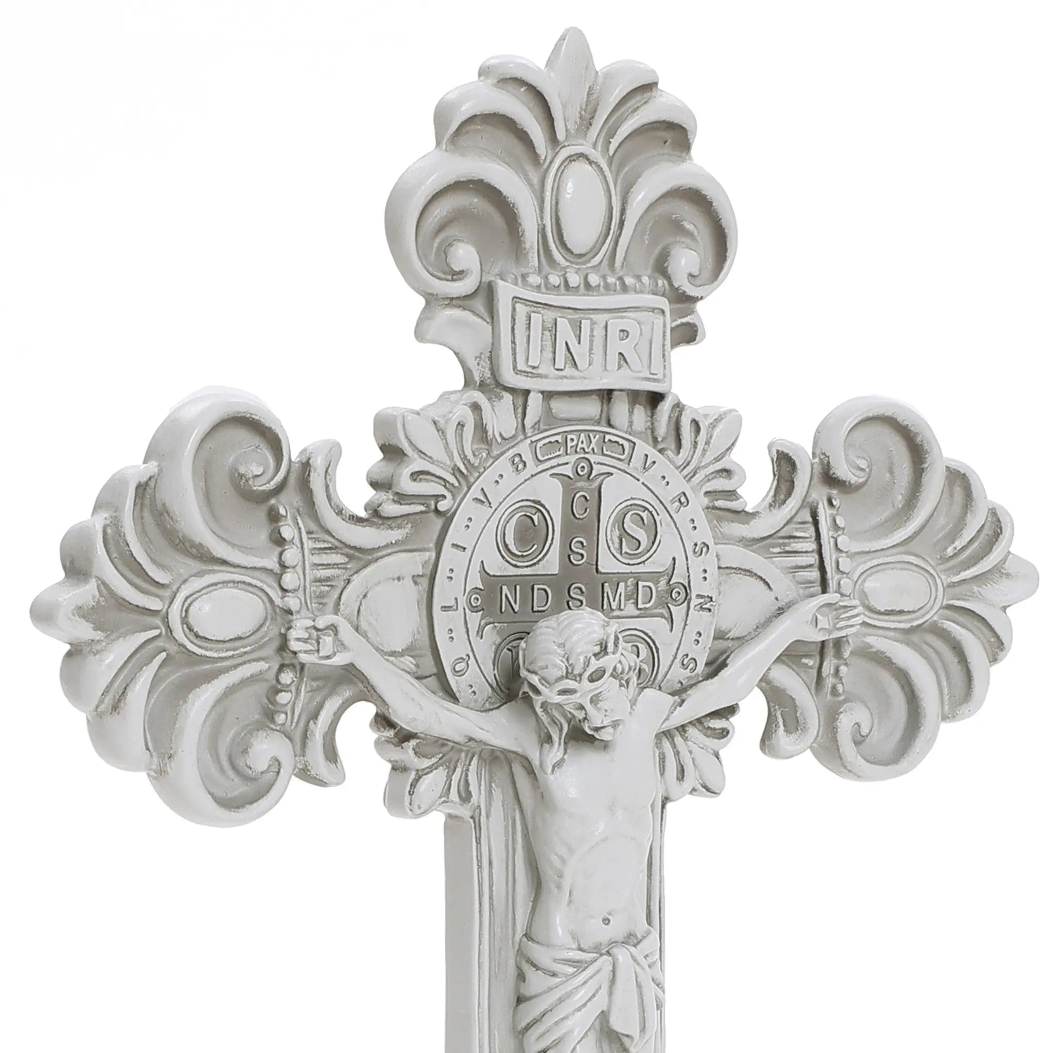 A white crucifix epitomizing Christian faith, showcasing a detailed depiction of Jesus, ornate designs, and a circular emblem with Latin inscriptions at the center. Perfect for religious occasions.
