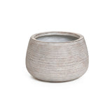 A sleek, round ceramic planter with a ribbed pattern and open top, featuring a minimalist design in light gray.
