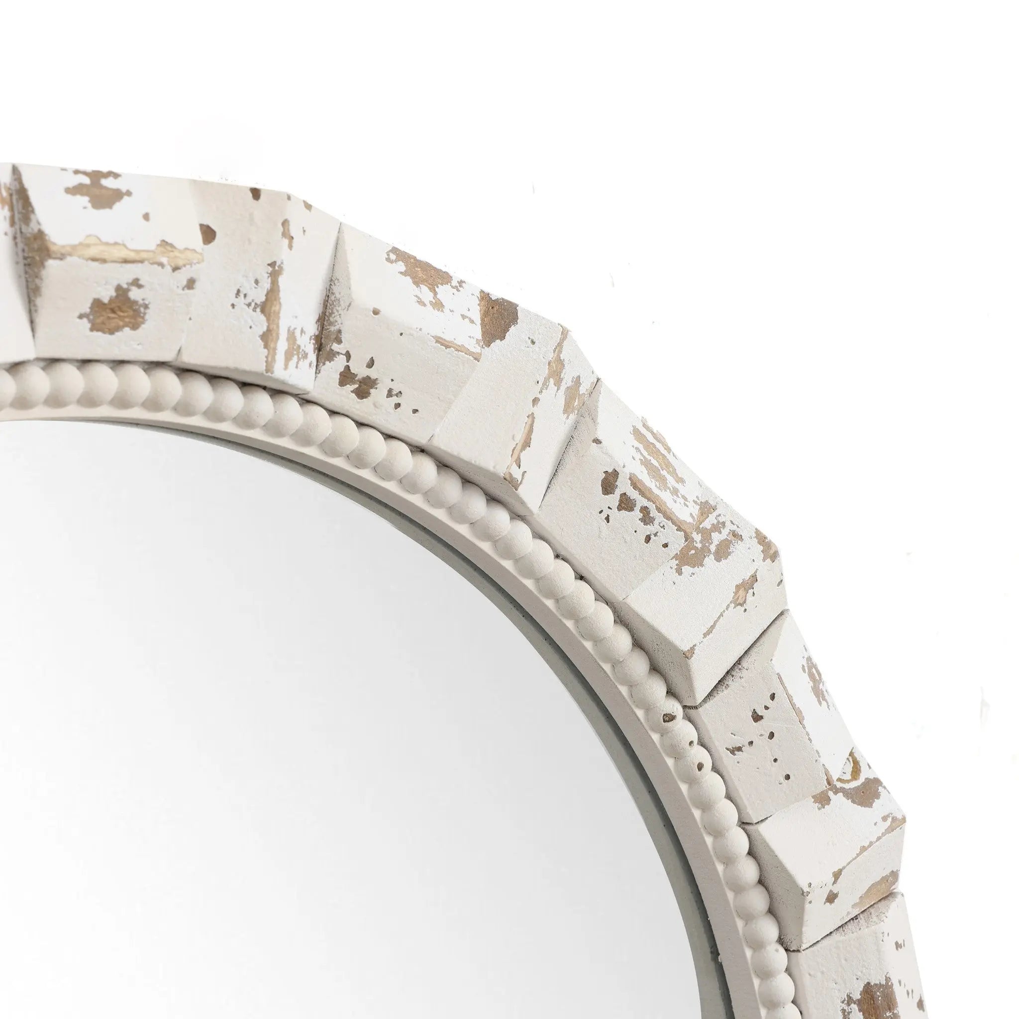 A close-up of a vintage wall mirror with a distressed white frame showcases an elegant, textured geometric design and small beaded details on the inner edge, making it a charming addition to any home decoration setup.
