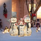 Three lighted snowmen with black-and-white scarves and hats stand in a snowy yard as charming outdoor Christmas decor, brightening up a house festively decorated for the holidays.