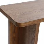 Close-up view of a wooden console table corner showcasing a natural wood grain pattern and smooth, rounded edge, embodying a mid-century modern minimalist design.