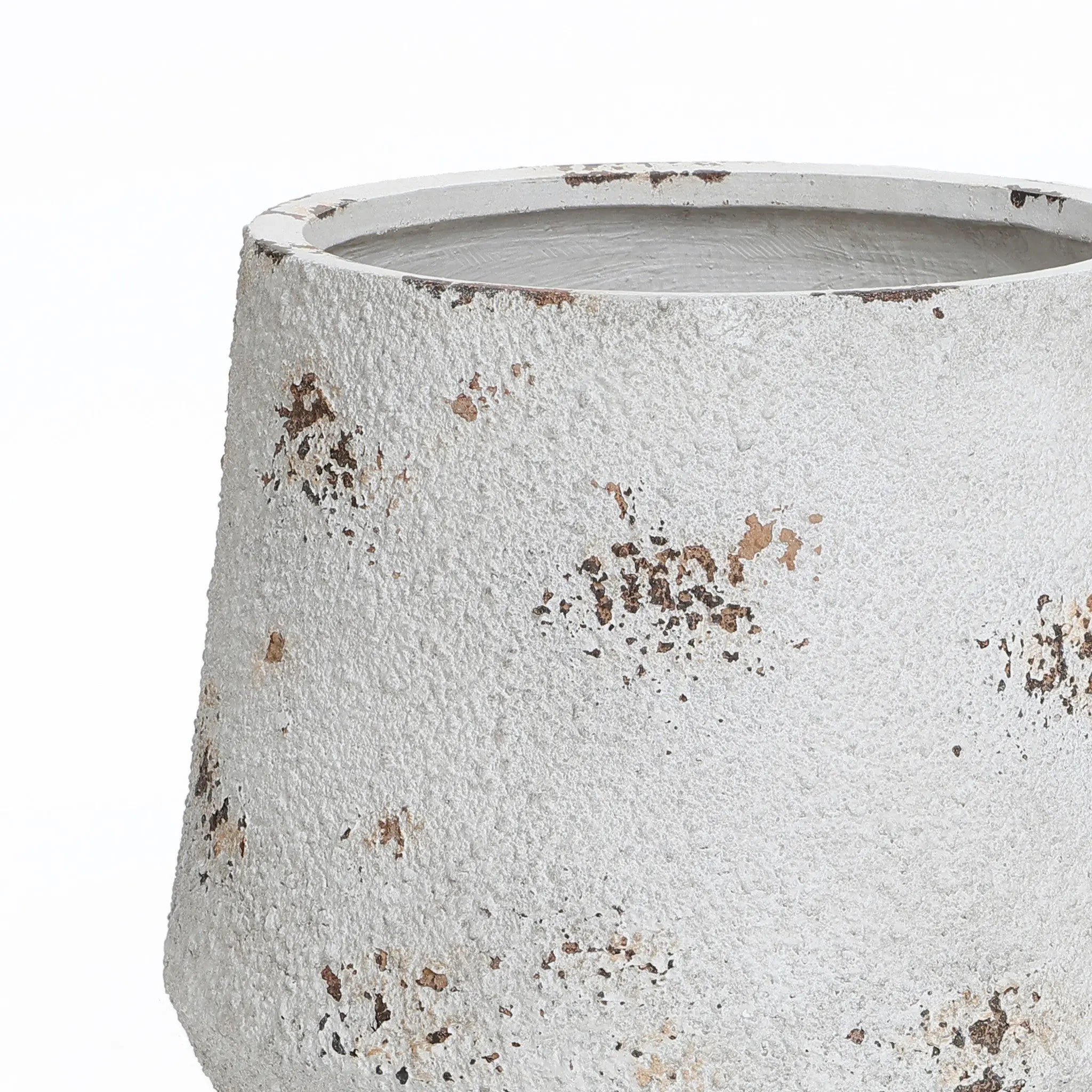 A textured, white ceramic pot with brown speckles and an unglazed rim, this round planter embodies a vintage minimalist style.