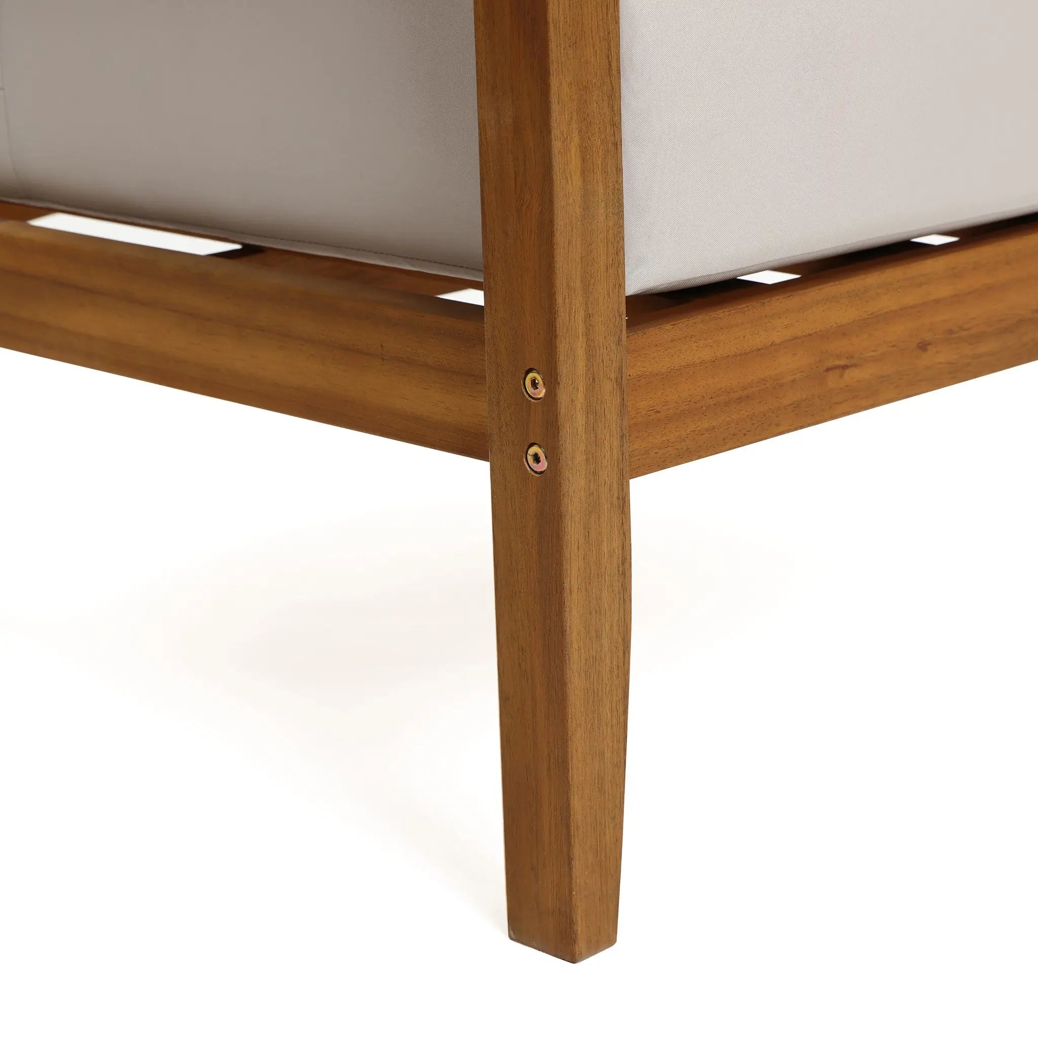 Close-up of a wooden furniture leg from an Outdoor Acacia Wood Rope Sides Loveseat, showing two visible screws and part of a light-colored upholstered cushion above.