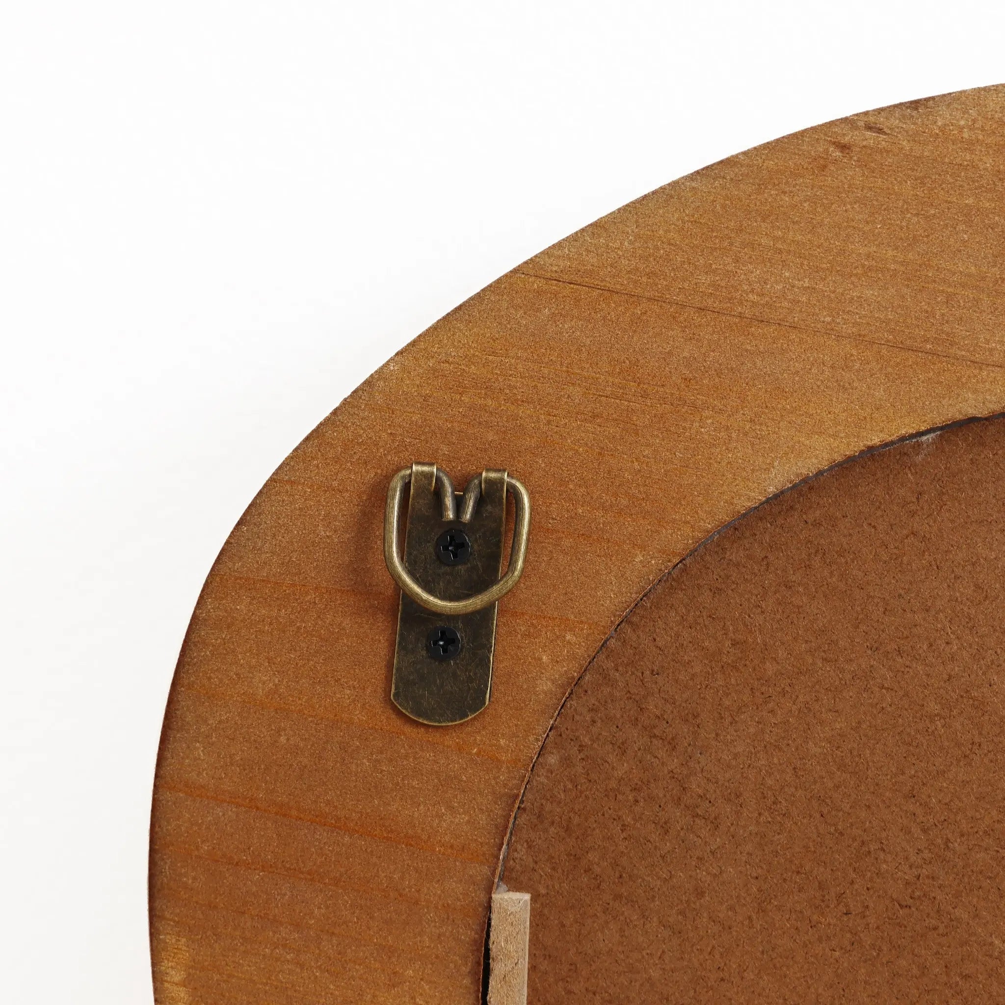 Close-up of a brass D-ring hanger on a wooden frame with a natural finish. The hanger is secured by two screws, ready to enhance your modern home decor with an oval irregularly shaped wall mirror.