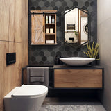 Modern bathroom with a striking hexagon shape tile wall, wood accents, vessel sink, wall-mounted toilet, and a black wall mirror reflecting a washing machine in an adjacent room.