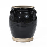 Black ceramic vase with two loop handles, a beige rim and base, showcasing an exquisite black glaze against a white background.