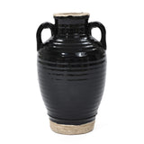 A handcrafted black ceramic vase with two handles and a textured surface, finished with a sleek black glaze.