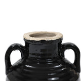 Close-up of a handcrafted black ceramic pot with two handles and a wide, unglazed rim, featuring a subtle black glaze.