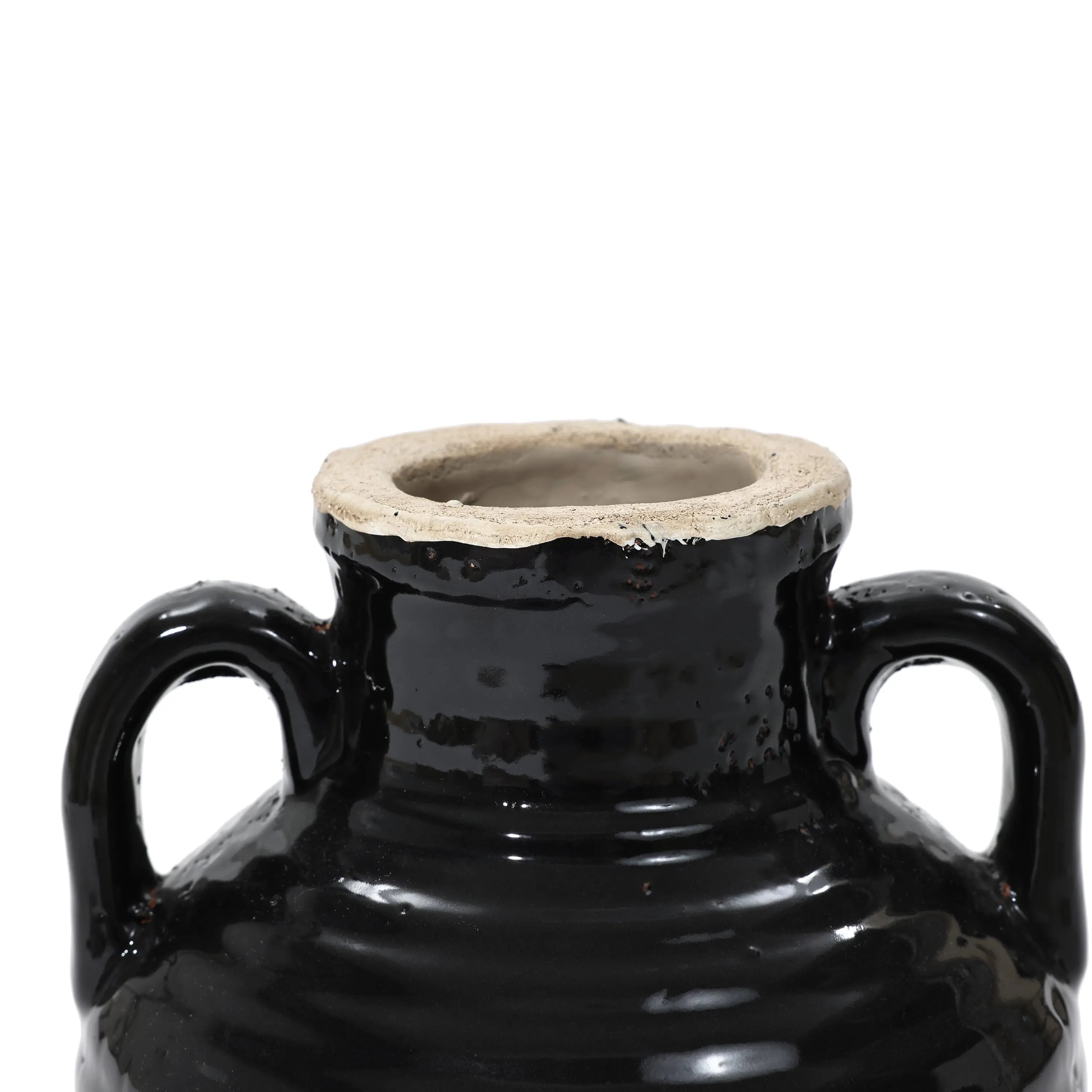 Close-up of a handcrafted black ceramic pot with two handles and a wide, unglazed rim, featuring a subtle black glaze.