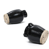 Two handcrafted black ceramic jars with ribbed textures and light-colored lids are shown lying on their sides against a white background, highlighting the smooth black glaze.