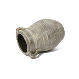 A large, historic-depth clay amphora with two handles lays on its side against a plain white background, echoing the artistry of a terracotta jug vase.