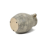A large, weathered terracotta jug vase lies on its side, revealing the bottom and light distress marks—a testament to its handcrafted nature and historic depth.