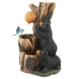 Two black bear figurines climb a tree stump with a beehive as water trickles down, while a blue bird perches nearby in this charming bear outdoor fountain—perfect for your garden or patio. Crafted from durable resin for lasting beauty.