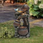 A decorative outdoor fountain with three rustic pots and a small blue bird, featuring water flowing from the top jar to the bottom, enhanced by LED lights, perfect for adding charm to your grassy lawn.