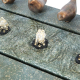 Close-up of a stone or ceramic outdoor fountain with flowing water bubbling from small jets, and decorative bird figurines placed along the edge—perfect for your patio or garden.