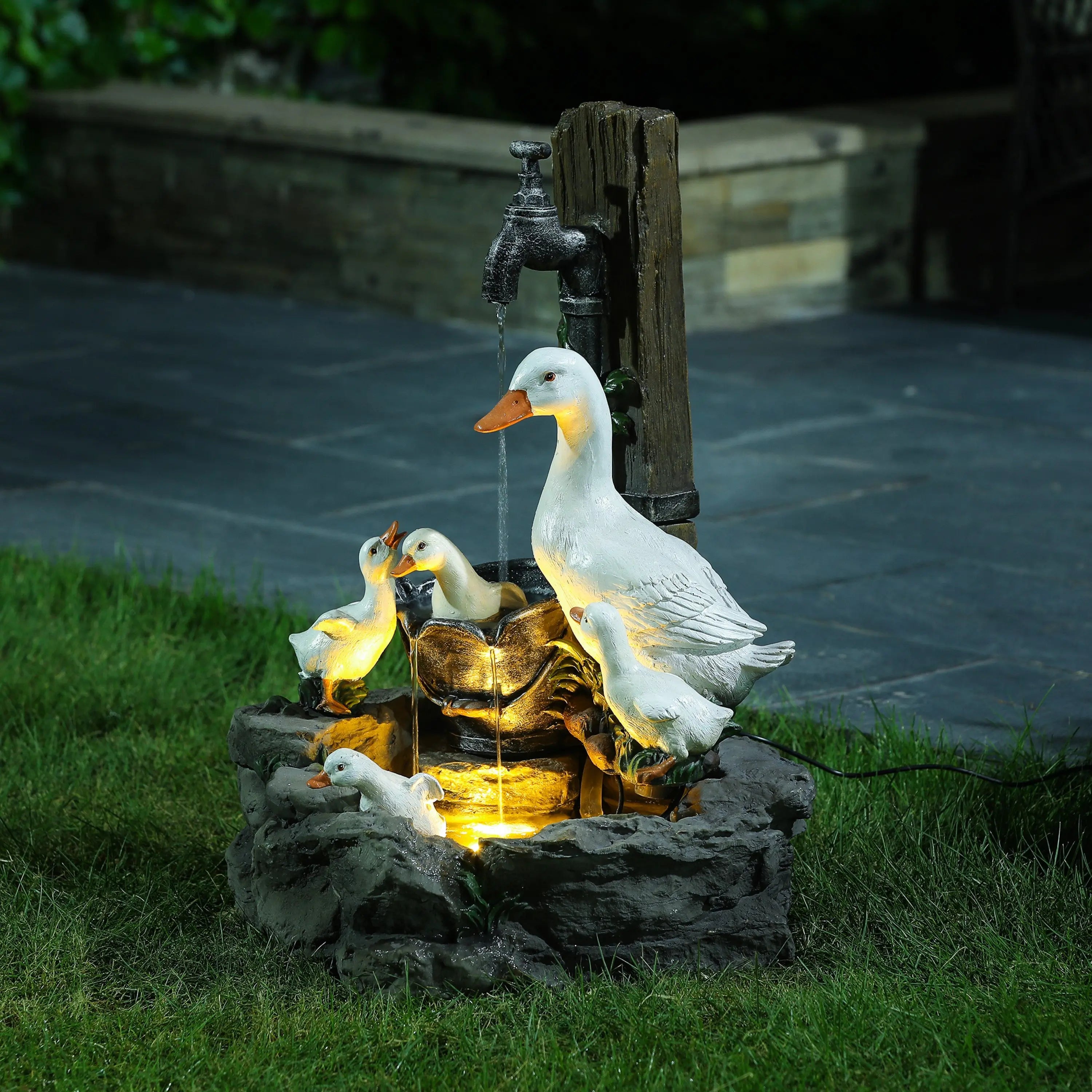 A decorative resin water fountain for your outdoor space, featuring illuminated duck and duckling statues with LED lights around a stone basin as water flows from the tap.