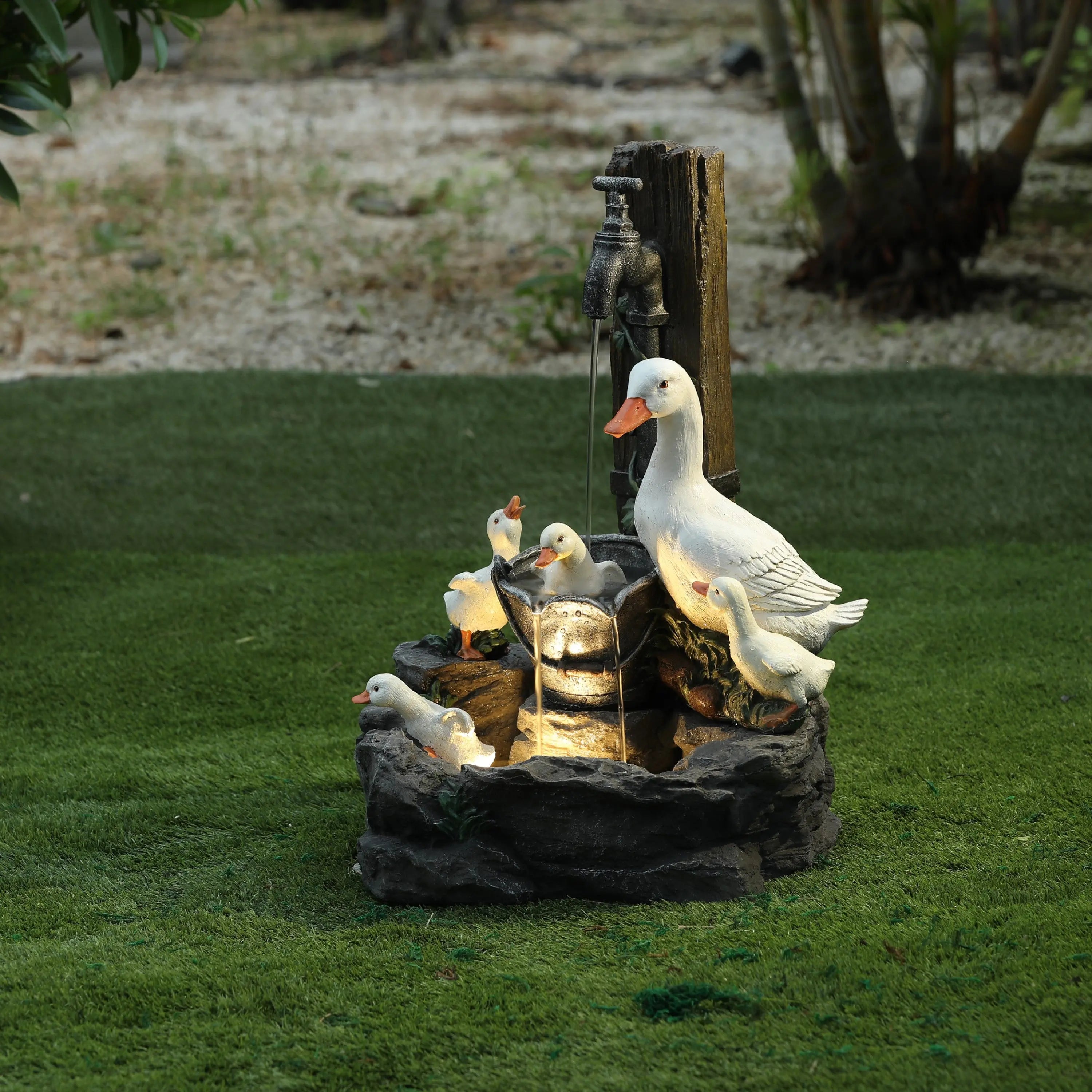 A decorative resin water fountain features a mother duck and five ducklings surrounding a water spout with an LED light, adding charm to any outdoor space.