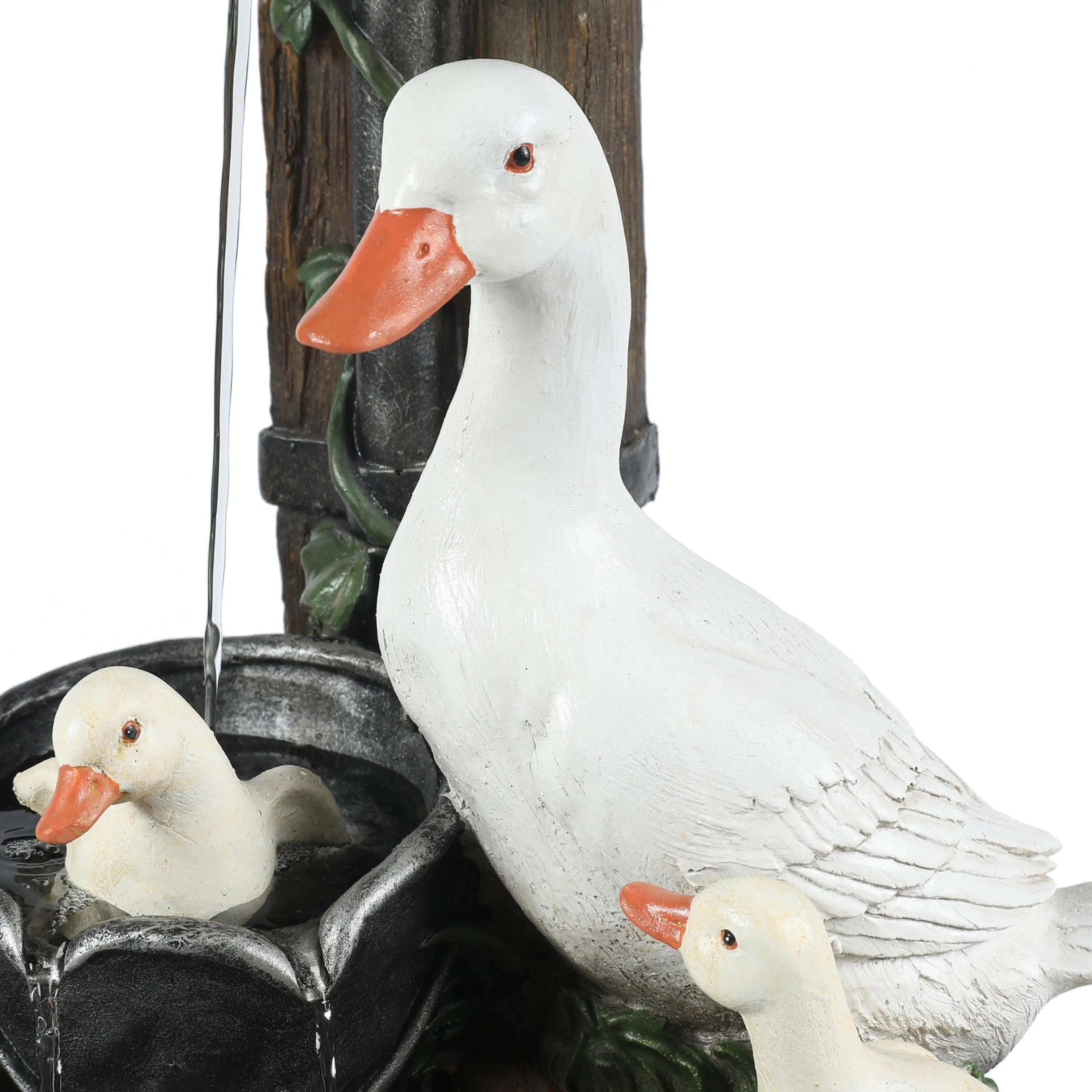 A close-up of three white duck statues, including one standing duck and two ducklings, with one sitting in a resin water fountain with water flowing—perfect for brightening any outdoor space.