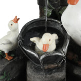 A close-up of a resin water fountain featuring three white duck statues, with one duck sitting in a black basin filled with water—perfect for brightening up any outdoor space.