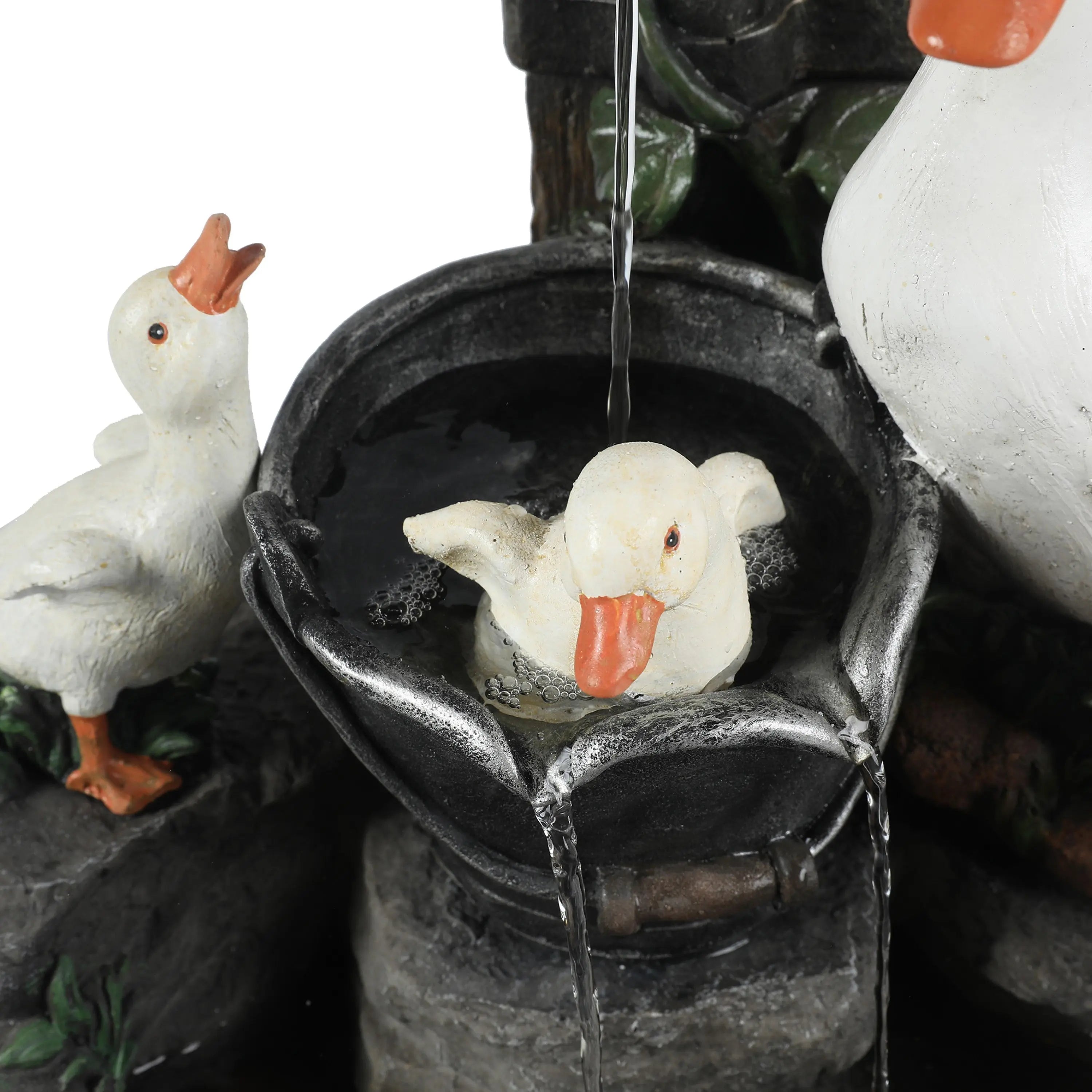 A close-up of a resin water fountain featuring three white duck statues, with one duck sitting in a black basin filled with water—perfect for brightening up any outdoor space.
