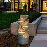 water fountain with lights on by the side of an entryway of a modern home