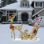 A Reindeer and Sleigh holiday decoration with LED lights stands in the snowy front yard, while a snowman and festive wreaths adorn the area near the front door.