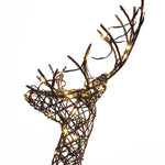 A decorative holiday reindeer sculpture made of woven branches, wrapped with small yellow LED lights, stands against a plain white background—a perfect holiday decoration for any space.