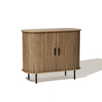 Mid-Century Modern Accent Cabinet featuring an oak grain finish, with rounded edges, two front slatted tambour doors, vertical grooves, and black metal legs.