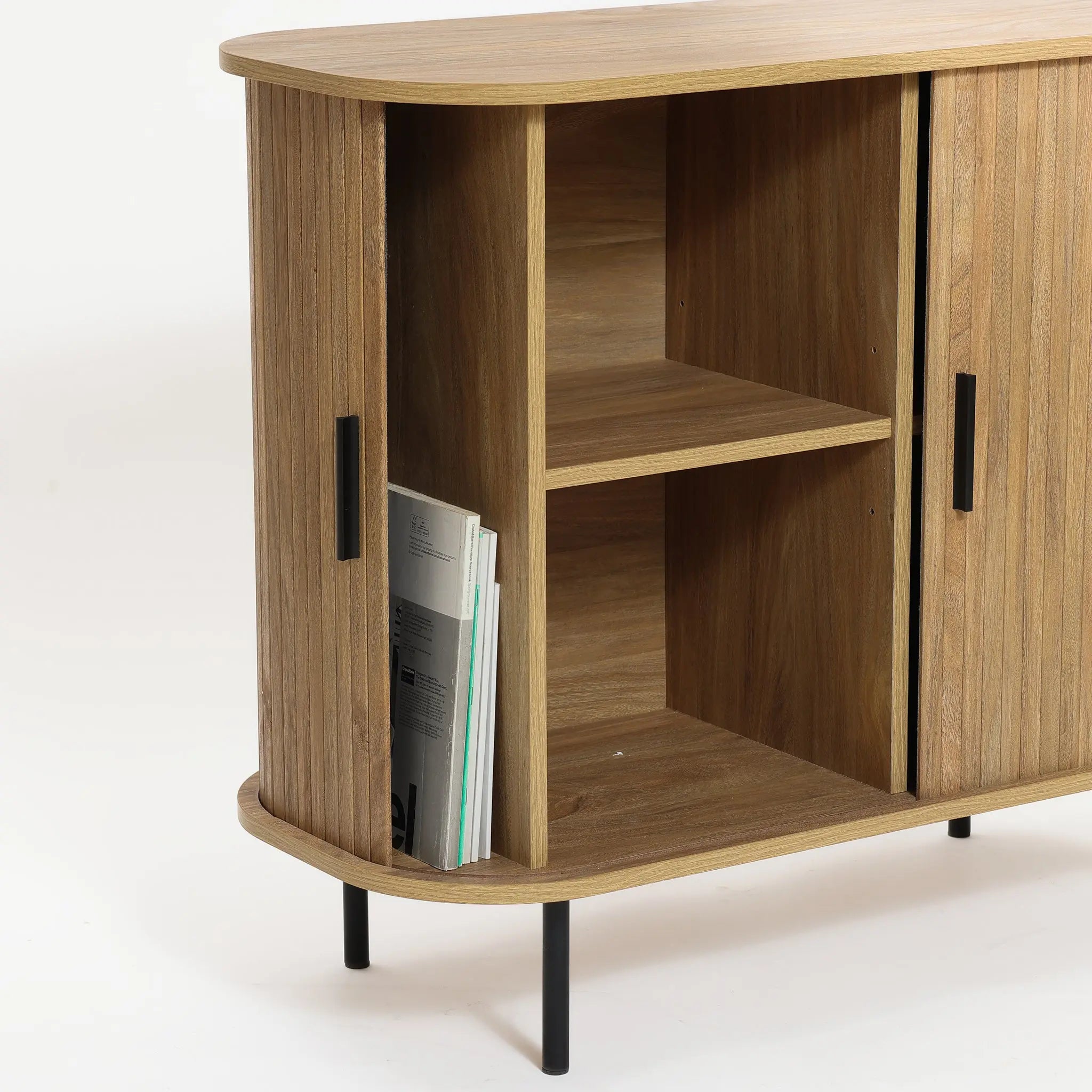 Mid-Century Modern Accent Cabinet featuring an oak grain finish and black handles, this wooden cabinet boasts open shelves with magazines stored vertically in the left shelf. Slatted tambour doors add a stylish touch to its design.