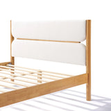 A solid wood bed featuring a white upholstered headboard and slatted base exudes modern sophistication against a pristine backdrop.