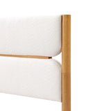 A corner of a solid wood bed features a wooden-framed headboard with padded, luxurious white boucle fabric, exuding modern sophistication.