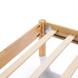 Close-up of a solid wood bed frame corner showing slats attached to metal brackets and round legs, exuding modern sophistication.