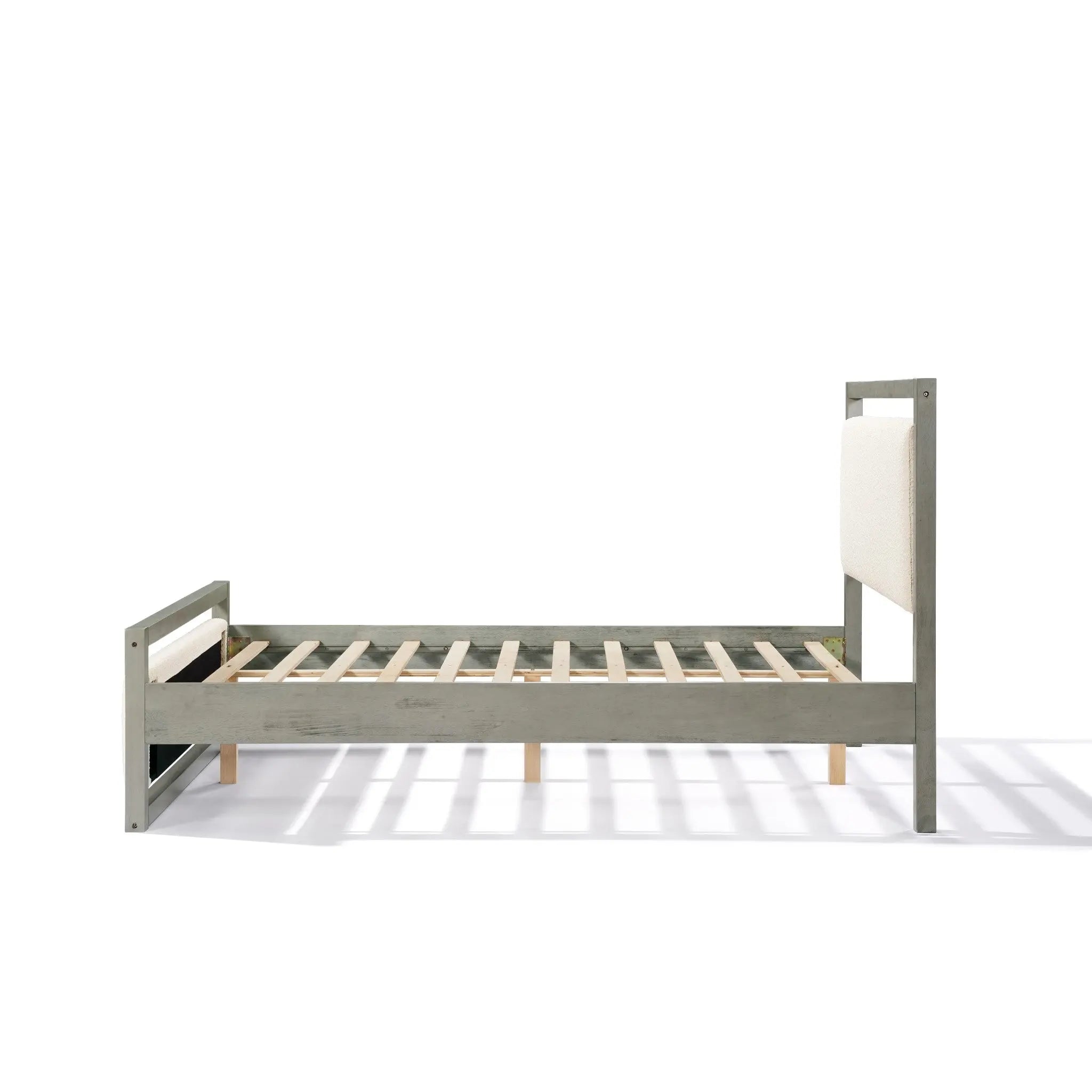 A side view of a modern bedroom piece featuring a gray bed frame with a wooden structure and an upholstered headboard. The bed frame has slatted wood supports and a minimalist design, complementing the white boucle headboard effortlessly.