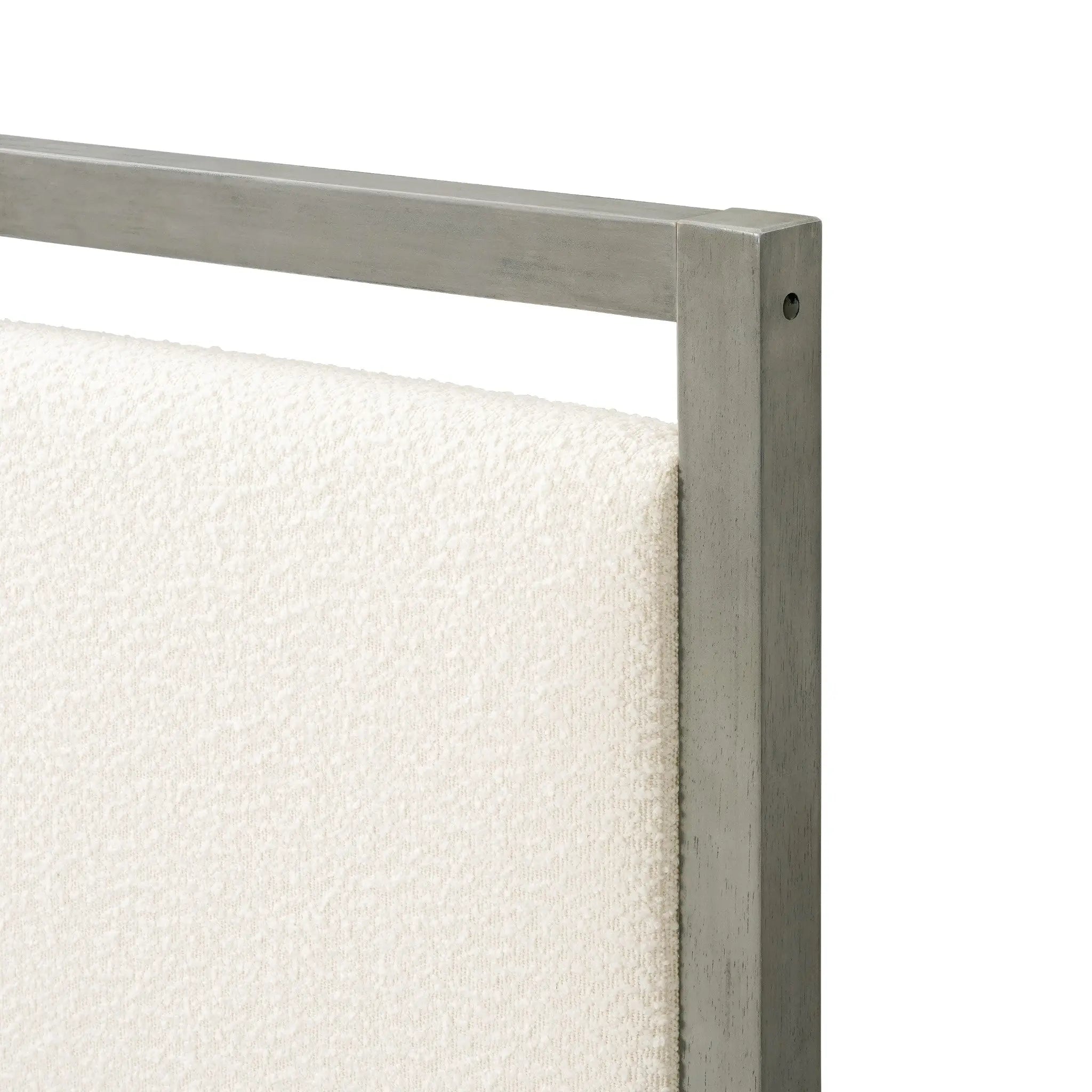 Close-up of a beige upholstered headboard with a sleek gray bed frame, perfect for a modern bedroom.
