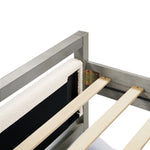 Close-up of a partially assembled gray bed frame with two slats and a metal bracket. A padded section is attached to one side, complementing the sleek design. Perfect for a modern bedroom aesthetic.