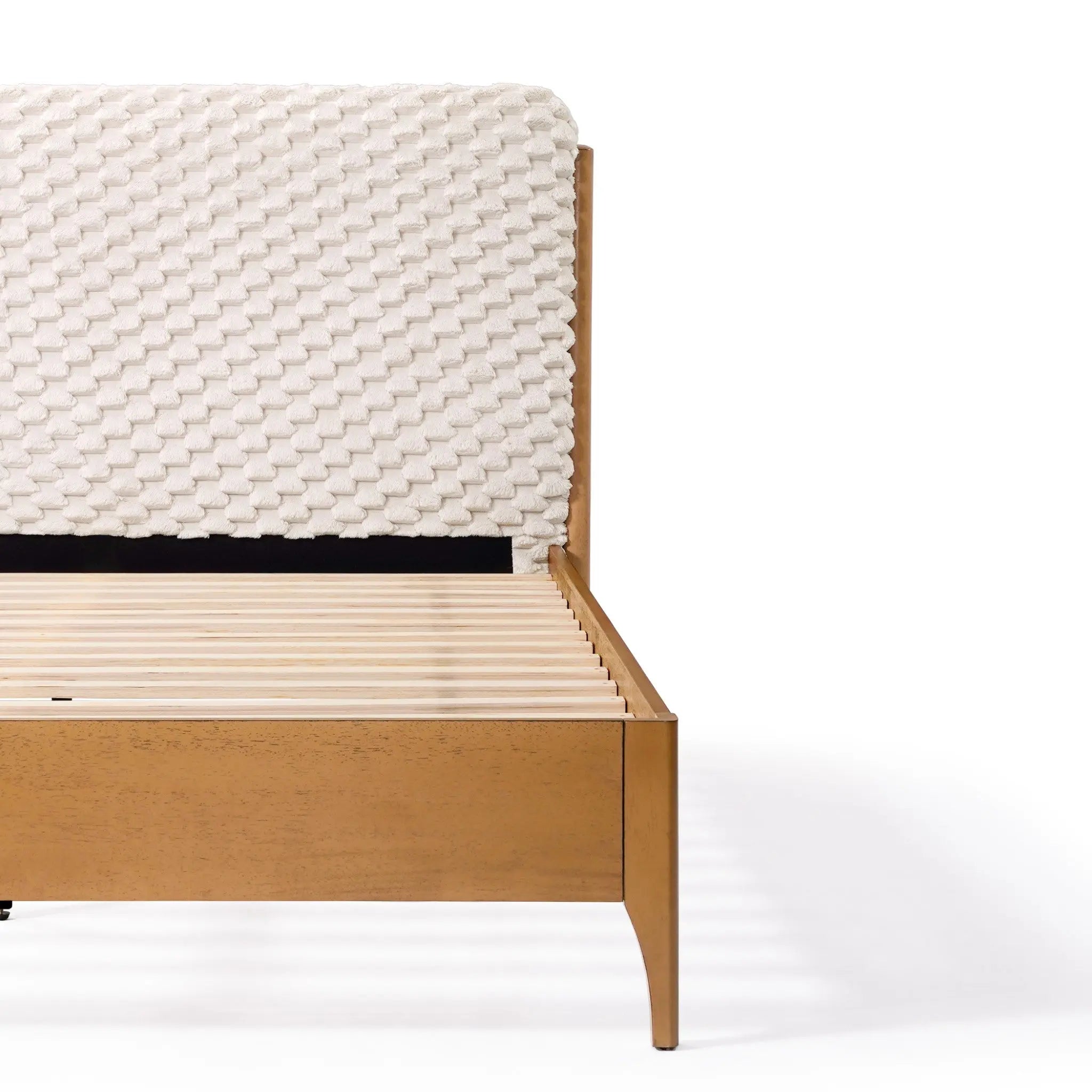 A Rubberwood Platform Bed, featuring a textured, woven headboard in light fabric, is partially shown. The slats are visible, enhancing its modern and minimalist design with a contemporary visual dimension.