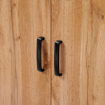 Close-up of two black handles on the Randolph wood accent sideboard by LuxenHome, featuring a modern walnut finish with light brown grain. The vertical handles are near the center seam of the cabinet doors, adding functionality and style to your storage space.