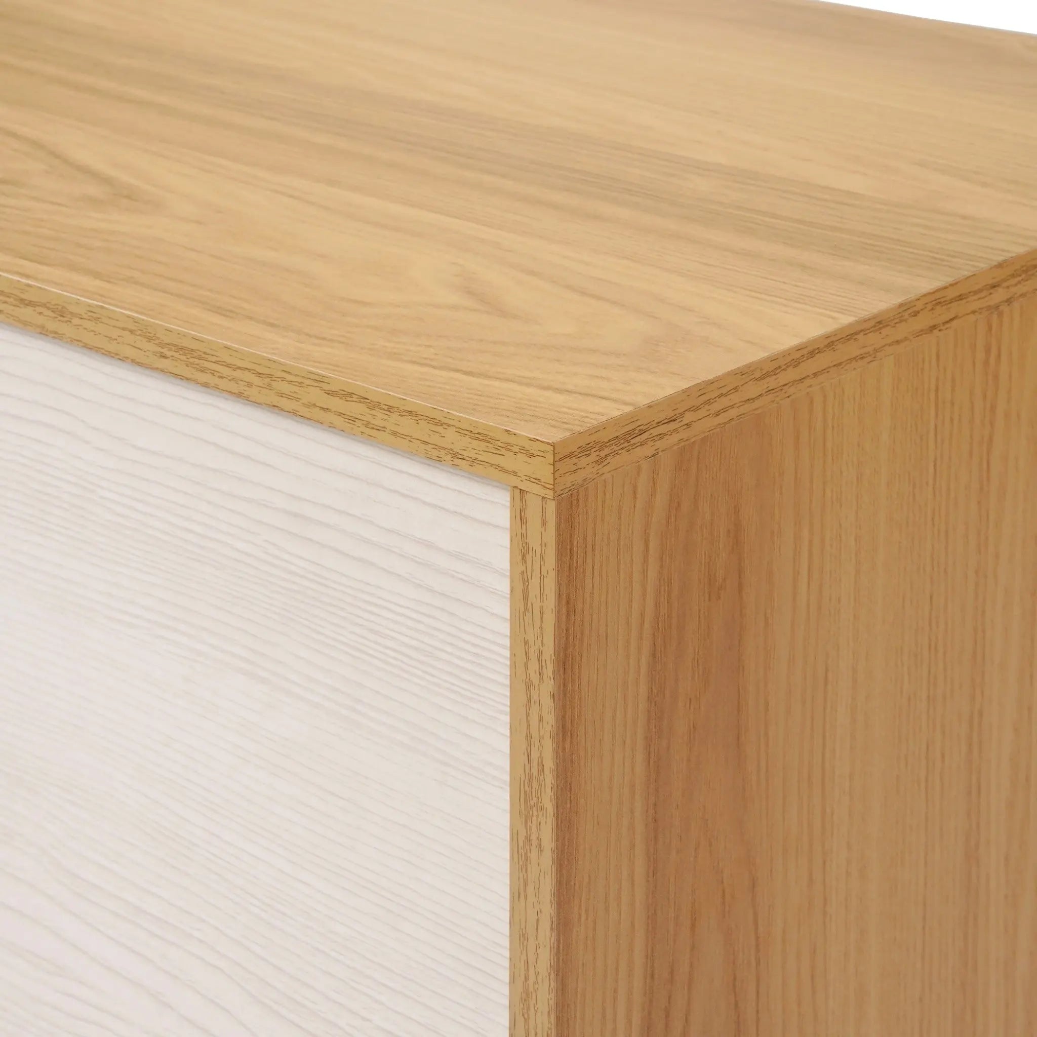 Close-up of a mid-century modern dresser corner, showcasing a combination of light and dark wood grain textures.