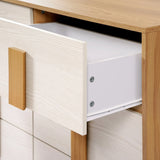 A wooden 3-tier dresser with a light finish features an open drawer, revealing its white interior. Embracing a minimalist design, it showcases large, rectangular handles that add to its sleek aesthetic.