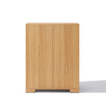 This wooden cabinet, with its minimalist flair, features two doors and a light oak finish, seamlessly blending into any space as an ideal storage solution inspired by mid-century modern design.