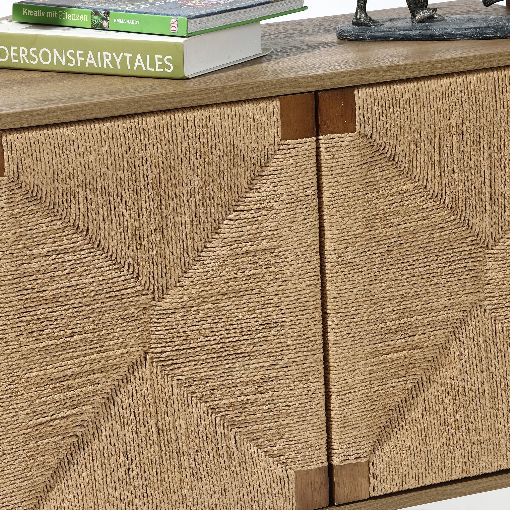 The LuxenHome Kaia rope & wood finish etagere bookcase features a ladder-style design with textured, handcrafted woven rope patterns on its cabinet doors. The top is elegantly adorned with two books and a small sculpture.