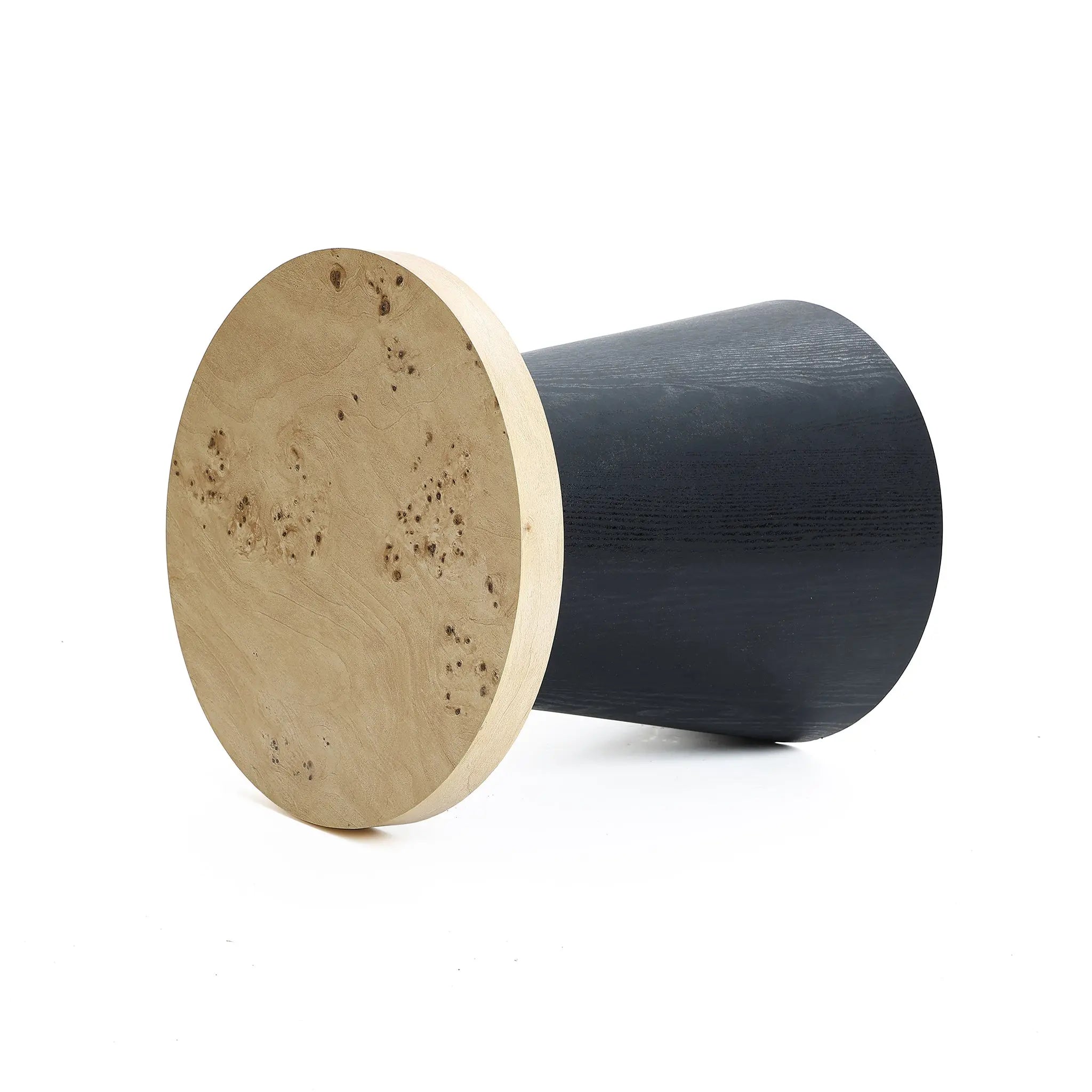 A modern, two-toned cylindrical stool with a tree burl texture lies on its side, showcasing a light, textured wooden top and a smooth, dark base. Perfect as a side table or seating option with lightweight MDF construction for easy mobility.