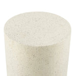 A close-up view of a cylindrical object with a smooth, speckled beige surface, likely made of stone or concrete, perfect as a modern patio table for contemporary design in outdoor furniture.