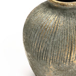 A close-up of the LuxenHome Rustic gold and brown terracotta bud vase, 8.7 h, showcases its textured round design with a ribbed pattern and antique distressed look. The earthy, metallic gray and gold finish adds elegance, ideal for home decor against a plain white background.