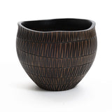 A small, round dark brown resin planter by LuxenHome with vertical grooves and a slightly uneven rim, set against a white background.