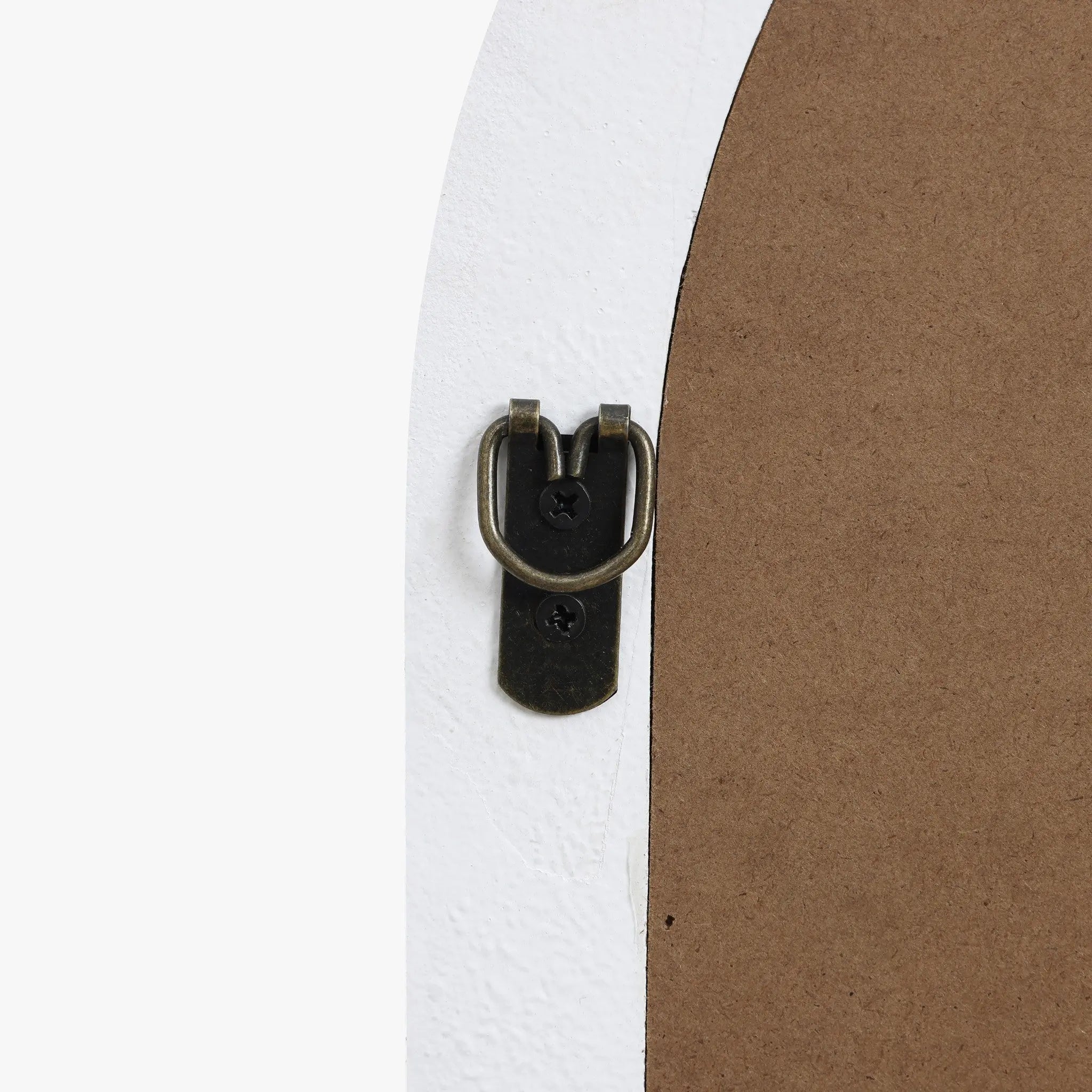 Close-up of a black metal D-ring hanger on the back of a framed object, exuding modernist elegance against a white background and brown backing.