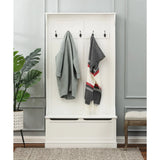 A white hall tree with black hooks serves as a coat rack, holding a gray coat and a striped scarf. A potted plant, storage bench, and gray rug are nearby.