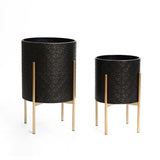 An elegant planter set featuring two black cylindrical planters with textured surfaces, beautifully supported by gold metal stands.